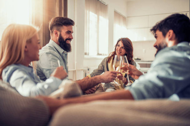 Skupina přátel s skvělý čas spolu doma, pití vína. - Fotografie, Obrázek