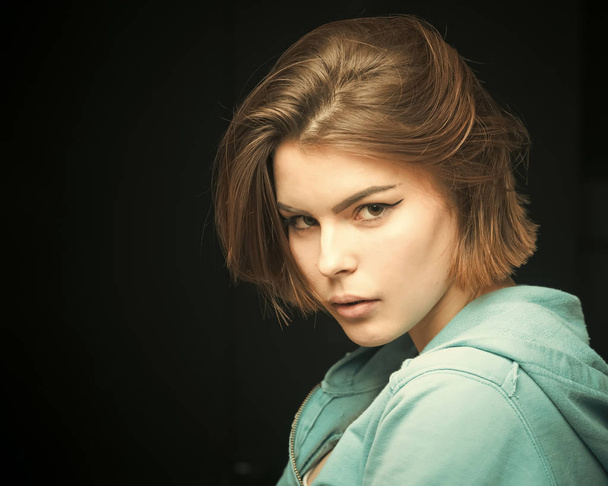 plastic surgery Woman on mysterious face with make up, black background. Pretty woman with hairstyle. Girl with fresh haircut, enjoying new hairstyle. Fashion shot of girl with bob haircut . Hairstyle - 写真・画像