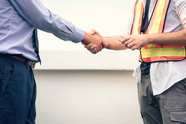 Businessman and engineer handshake after deal successfully at construction site. - Foto, imagen