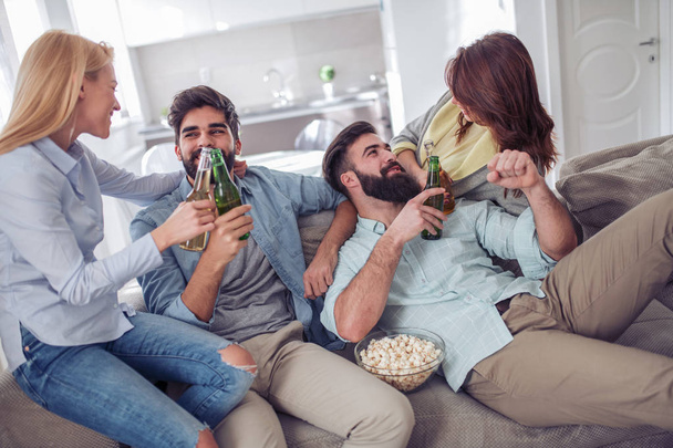 Grupo de amigos viendo partidos de fútbol en casa, divirtiéndose
. - Foto, imagen