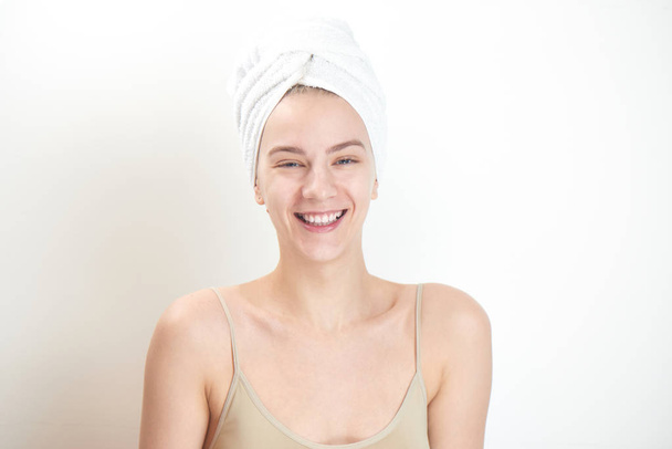 beautiful woman with towel on head perfect clean skin looking at camera and laughing isolated on white background  - Fotoğraf, Görsel