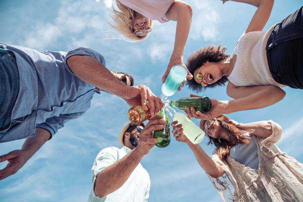 Grupo de amigos juntos na praia beber e se divertir
 - Foto, Imagem