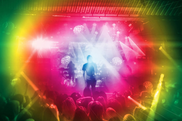 Silhouetten von Fans und Musikern auf der Bühne, helle Scheinwerfer bei Musikkonzert - Foto, Bild