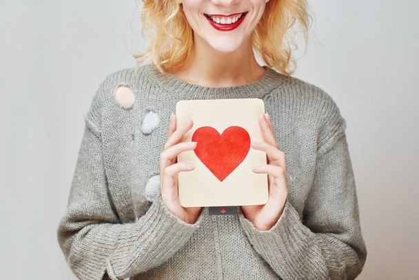 female hands holding card with heart on gray background, Valentines day concept, close-up  - Foto, Imagem