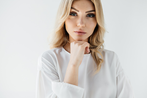 portrait of beautiful blond woman in white clothing posing on white backdrop - 写真・画像