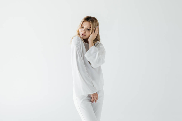 portrait de femme réfléchie en vêtements blancs posant isolé sur blanc
 - Photo, image