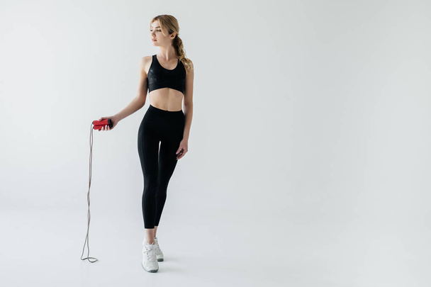 young sportive woman with skipping rope isolated on grey - Foto, immagini
