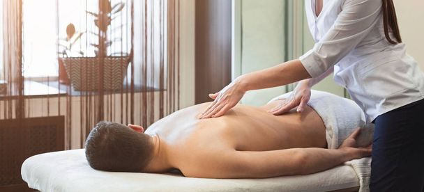 Mulher massageando ombros masculinos e costas
 - Foto, Imagem