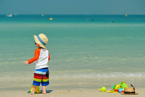 Dwuletni chłopiec maluch bawi się zabawkami beach na plaży  - Zdjęcie, obraz