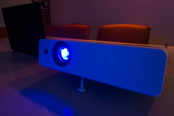 Projektor mit angeschlossenem Laptop zur Präsentation in einem Besprechungsraum mit Notebook-Hintergrund - Foto, Bild