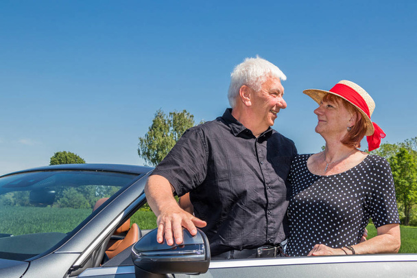 Senior couple in convertible car enjoying day trip - Photo, Image