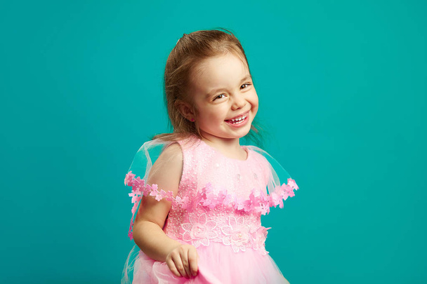 Cheerful little girl in beautiful pink dress - Фото, зображення
