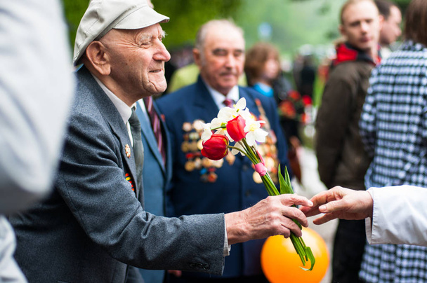 OBNINSK, RUSSIA - MAY 9, 2012: A veteran of the war receives flowers as gifts on the Day of Victory. - Foto, immagini