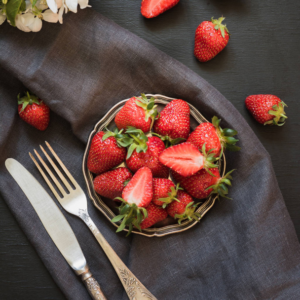 Fresh organic strawberry in vintage plate on black table. Summer. Top view. - Foto, Imagen