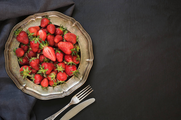 Fresh organic strawberry in vintage plate on black table. Summer. Top view. Space for you. - Foto, Imagen