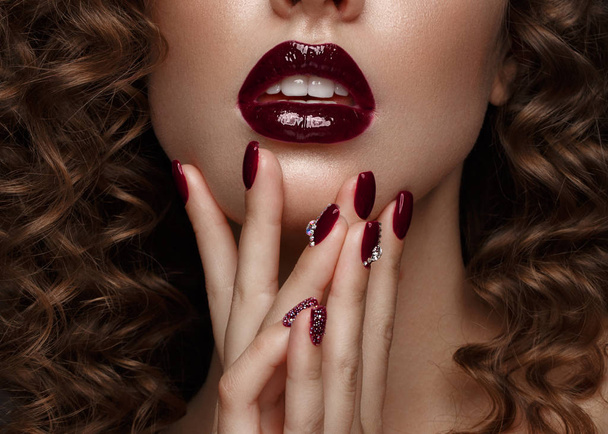 Beautiful girl with evening make-up, purple lips, curls and design manicure nails. beauty face. - Photo, image