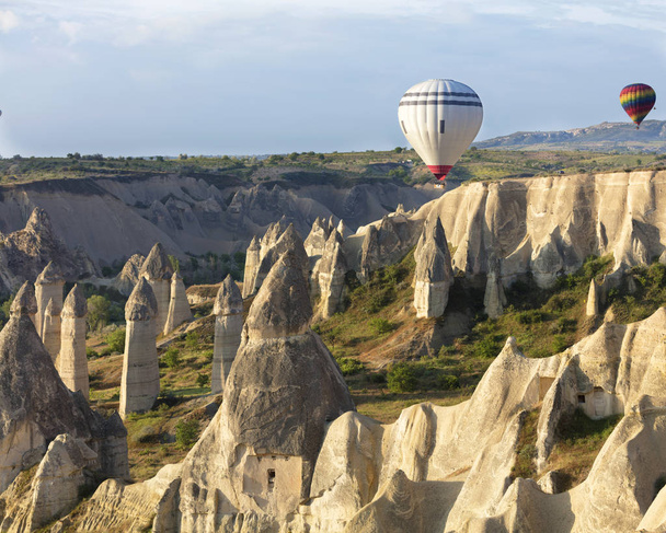 Een weergave van de gekleurde ballonnen vliegen over de vallei van de liefde bij dageraad. Cappadocië, Turkije. - Foto, afbeelding