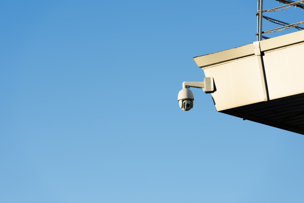 close up view of security camera on building facade with clear blue sky - Φωτογραφία, εικόνα