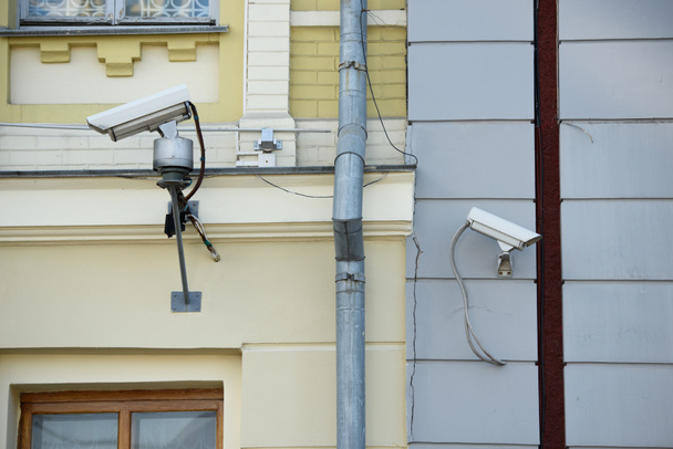 Close-up van bewakingscamera's op verschillende gebouwen gevels - Foto, afbeelding