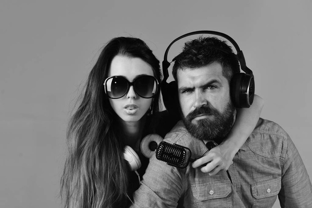 Couple in love wears headphones and holds microphone. - Φωτογραφία, εικόνα