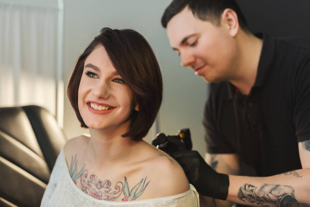 Tatuaje artista trabajando con aguja en el cuerpo de los clientes
 - Foto, imagen