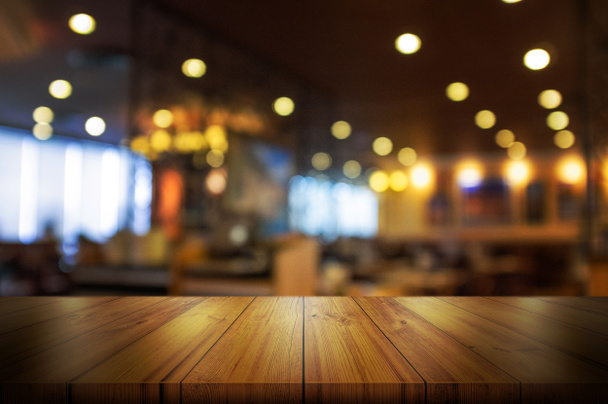 Empty wooden table top with blur coffee shop or restaurant interior background. Abstract background can be used product display.  - Zdjęcie, obraz