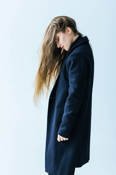 Young caucasian woman in black coat - 写真・画像