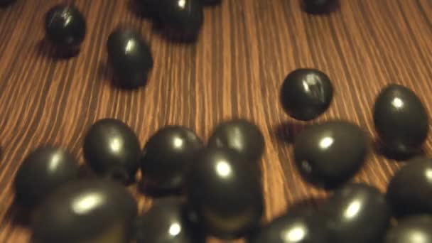 Black olives on a brown wooden background. 2 Shots. Slow motion. Close-up.1. Olives are rolling down on a brown wooden background and fills all space the frame.2. Vertical ( from top to bottom ) pan.  - Footage, Video