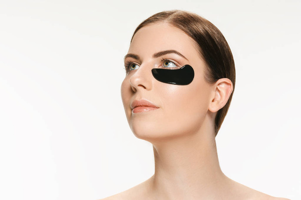 Młoda kobieta piękne stosowania maski do twarzy z czarnego błota lecznicze. Leczenie uzdrowiskowe - Zdjęcie, obraz