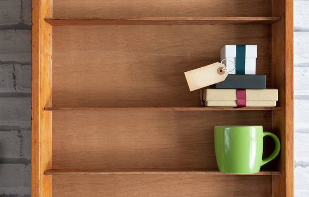 Gifts with blank label inside a shelf unit with coffee cup - Foto, Imagem