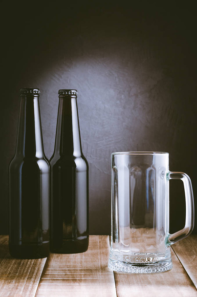 two bottle and beer mug on a dark background/two bottle and beer mug on a dark style. Selective focus - Foto, Imagem
