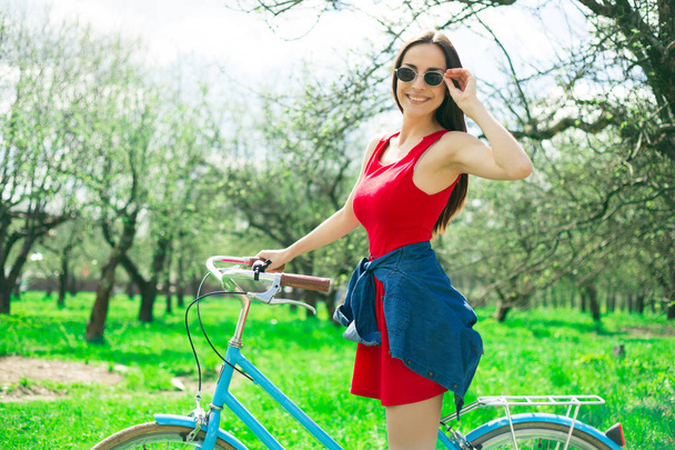 fiatal nő pózol a kültéri kerékpáros napszemüveg - Fotó, kép