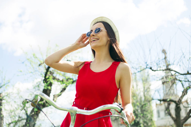 young woman in sunglasses posing on bike outdoor - Foto, Imagem
