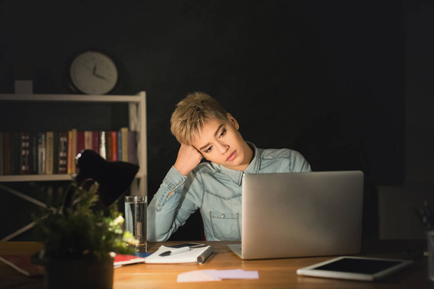 Κουρασμένος ελεύθερος επαγγελματίας εργάζεται σε φορητό υπολογιστή στο σπίτι μέχρι αργά το βράδυ - Φωτογραφία, εικόνα