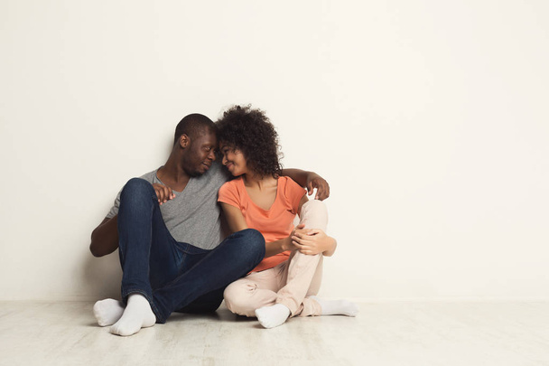 Couple afro-américain étreignant, assis sur le sol
 - Photo, image