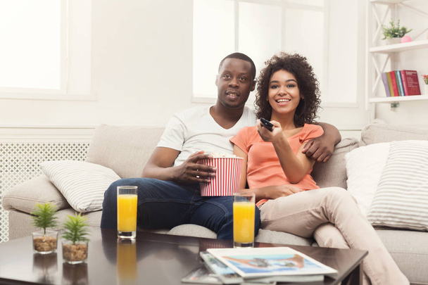 Happy african-american couple watching TV at home - Foto, Bild