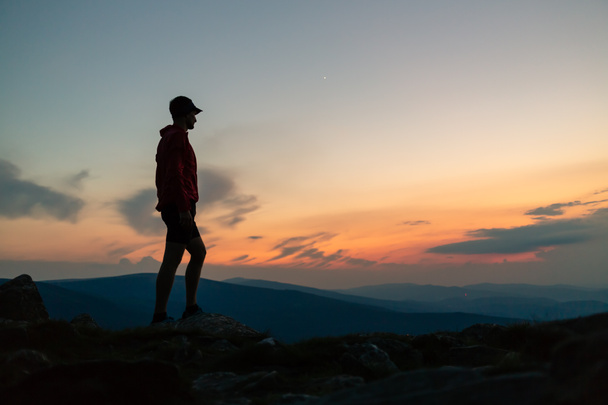 Muž slaví západ slunce na vrchol hory. Při pohledu na inspirující pohled. Trail runner, turista či horolezec dosáhl vrcholu hory, si inspirující krajinu na kamenité stezce Karkonosze, Polsko - Fotografie, Obrázek