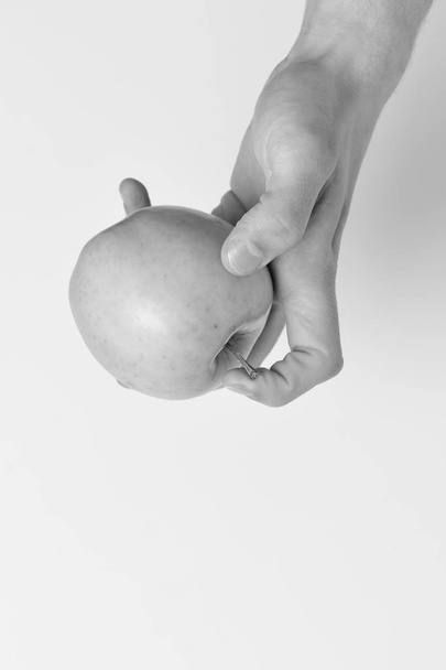 Male hand holds light green apple. Apple on white background - Zdjęcie, obraz