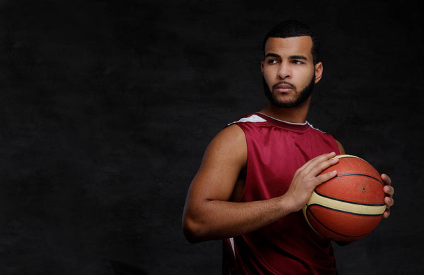 Young African-American basketball player in sportswear isolated over dark background. - Foto, immagini