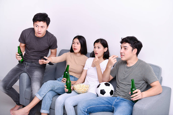 Concept of cheering. Asian teenagers watching football on television. People are cheering and winning football scores. - Foto, imagen
