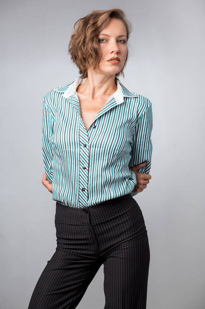 Woman in a shirt and pants isolated over gray background, studio shot - Foto, imagen