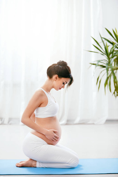 Terhes nő, testmozgás, jóga gyakorlása beltéri otthon. Nagy felbontású - Fotó, kép