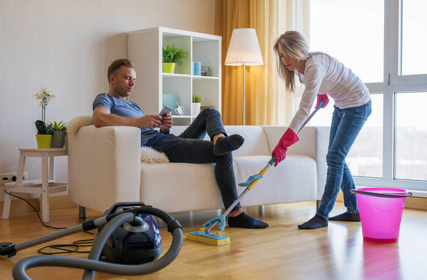 Woman cleaning home and man doesn't help her - Fotografie, Obrázek