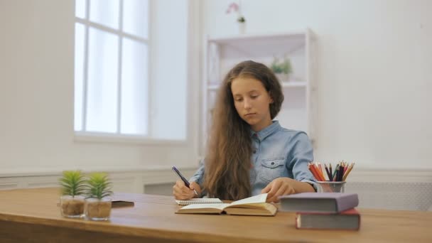 Dizüstü bilgisayar ile genç kız ev ödevi yapıyor. Üniversite eğitimi. Kız öğrenci evde ders çalışıyor. - Video, Çekim