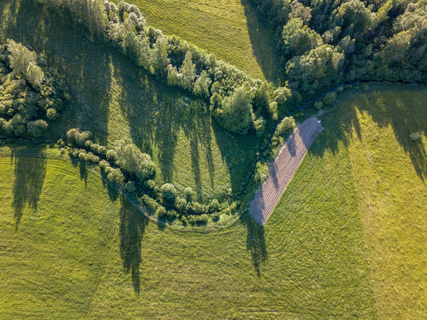 ドローンのイメージ。農村地域でのフィールド、曇り春の日の林の空撮。ラトビア - 写真・画像