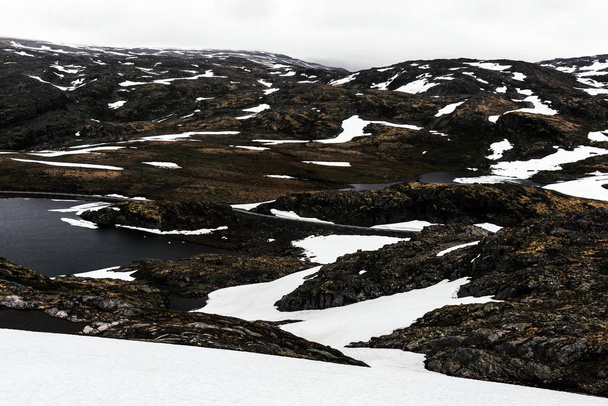 Typical norwegian landscape with snowy mountains - Foto, afbeelding