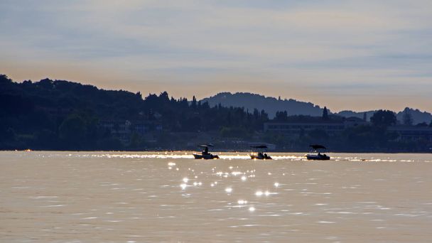 Tranquil scene with three motor boats in the calm sea at sunset. Small motor boats being towed on a tropical sea - Photo, Image