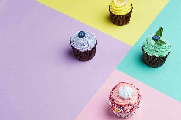 Cupcakes Desserts On Colorful Background. Cakes With Different Colors Cream And Toppings. High Resolution - 写真・画像