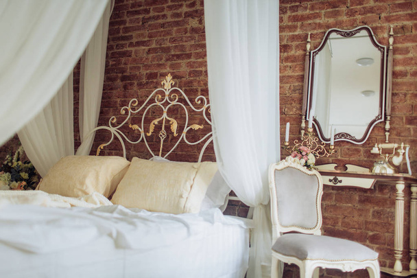 Loft dormitorio con pared de ladrillo blanco, cama doble y espejo
 - Foto, Imagen
