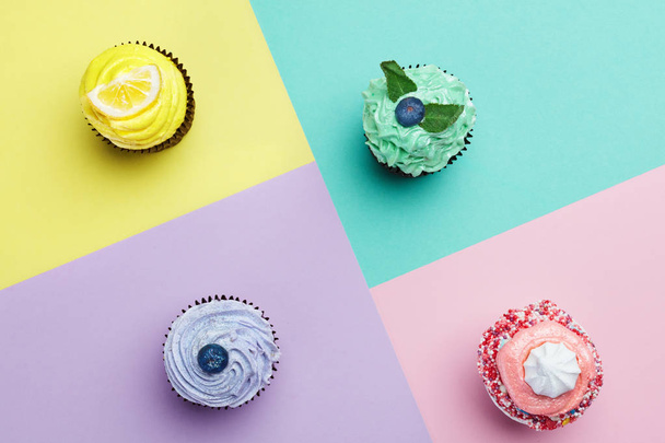 Cupcakes Desserts On Colorful Background. Cakes With Different Colors Cream And Toppings. High Resolution - Foto, afbeelding